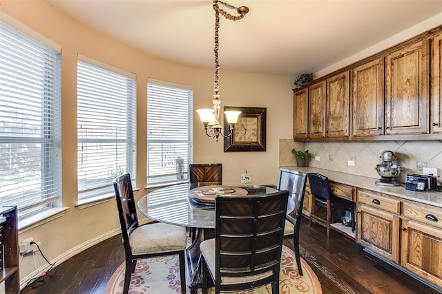 dining space featuring an inviting chandelier, dark hardwood / wood-style floors, and a healthy amount of sunlight