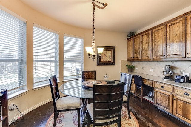 dining area featuring a chandelier, baseboards, dark wood-style flooring, and plenty of natural light