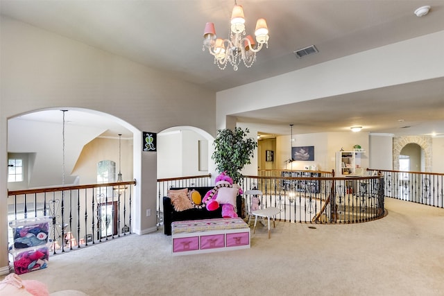 interior space featuring a chandelier, visible vents, carpet floors, and an upstairs landing
