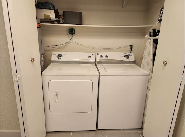 laundry area with light tile patterned floors and washing machine and clothes dryer