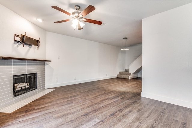 unfurnished living room with dark hardwood / wood-style floors, a fireplace, and ceiling fan