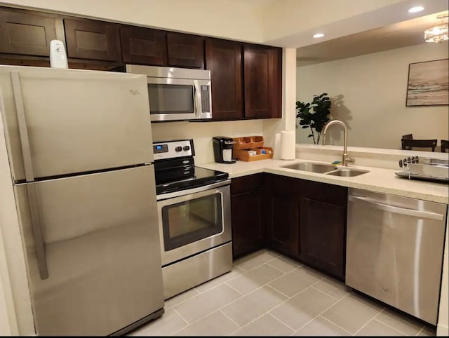 kitchen with light tile patterned floors, appliances with stainless steel finishes, sink, and dark brown cabinets