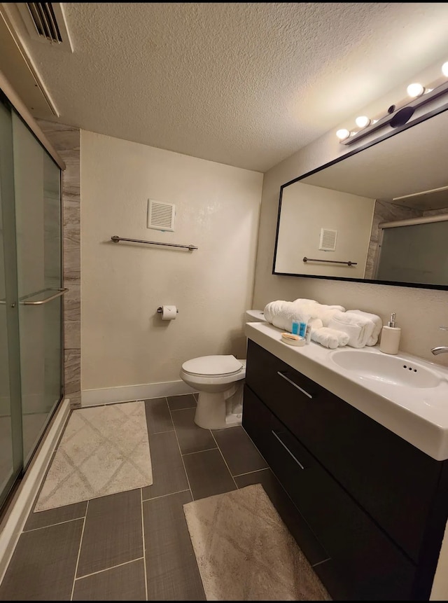 bathroom featuring a textured ceiling, an enclosed shower, toilet, tile patterned floors, and vanity