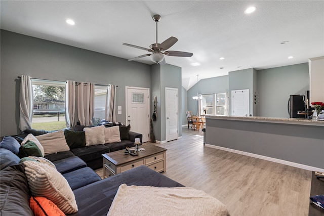 living room featuring light hardwood / wood-style floors and ceiling fan with notable chandelier