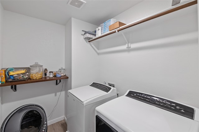 laundry area with washer and clothes dryer and hardwood / wood-style flooring