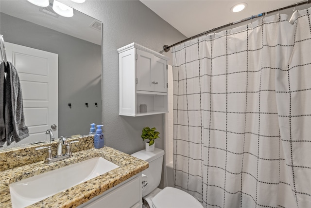 full bathroom with vanity, shower / tub combo with curtain, and toilet