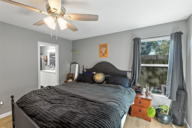 bedroom with sink, ceiling fan, ensuite bathroom, and light wood-type flooring