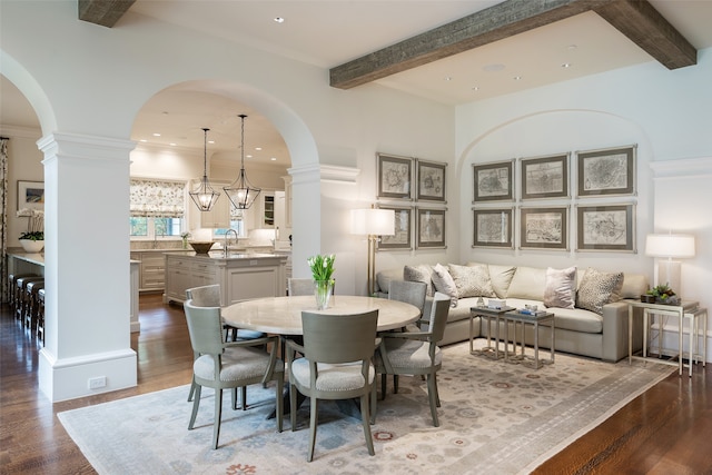 dining area with beam ceiling, sink, dark wood-type flooring, and a notable chandelier