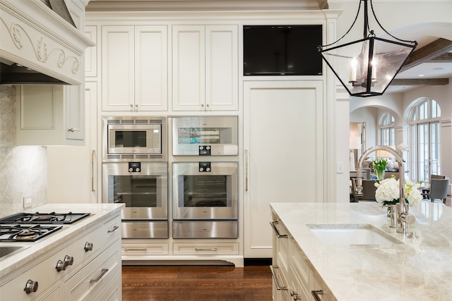 kitchen with dark hardwood / wood-style floors, sink, pendant lighting, double oven, and light stone counters