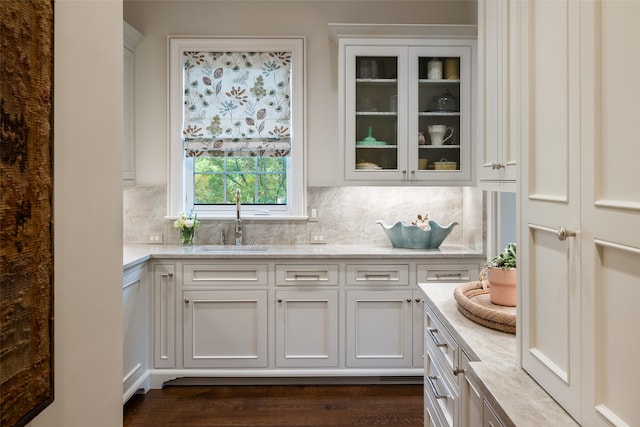 interior space with sink, tasteful backsplash, dark hardwood / wood-style flooring, and white cabinets