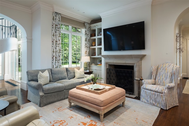 living room featuring crown molding, hardwood / wood-style floors, and built in features