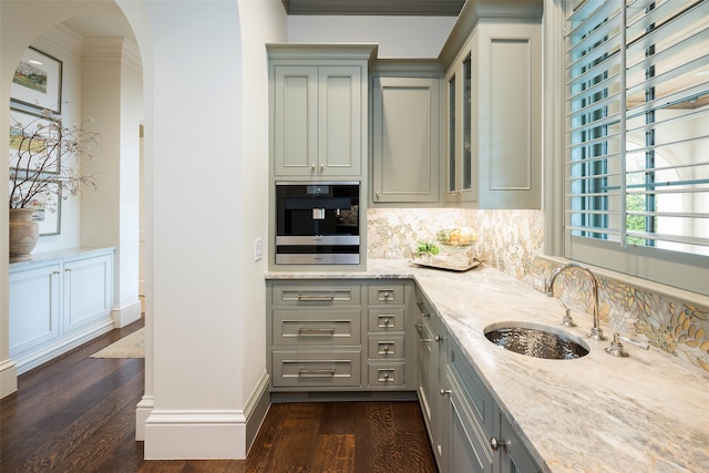 kitchen featuring light stone countertops, dark wood-type flooring, backsplash, and stainless steel oven