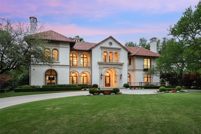 mediterranean / spanish house featuring a lawn