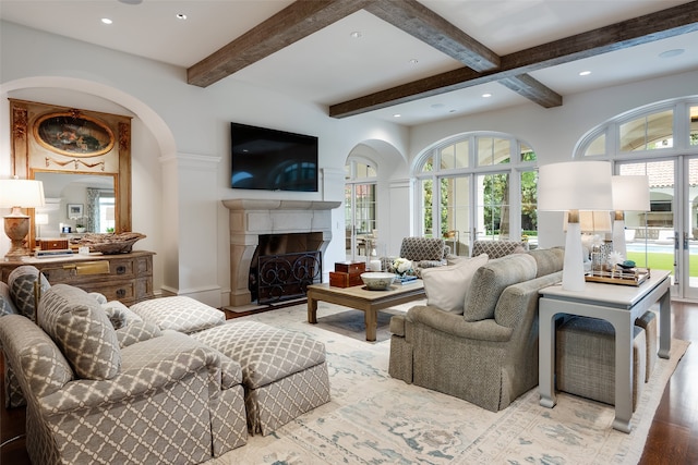 living room featuring hardwood / wood-style floors, a healthy amount of sunlight, and beamed ceiling