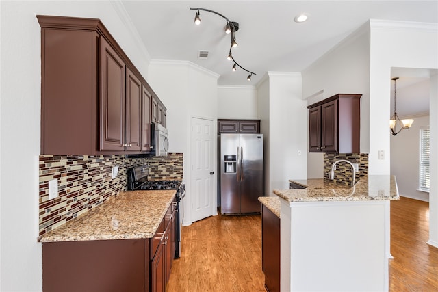 kitchen with appliances with stainless steel finishes, light hardwood / wood-style flooring, ornamental molding, and light stone countertops