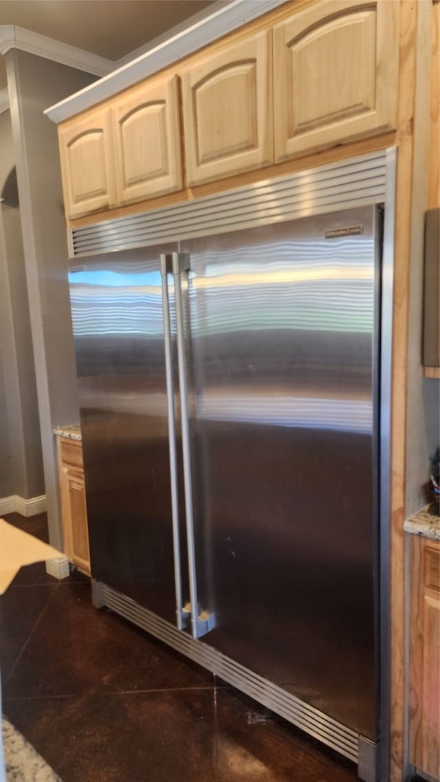 details with light brown cabinetry, built in refrigerator, crown molding, and light stone counters