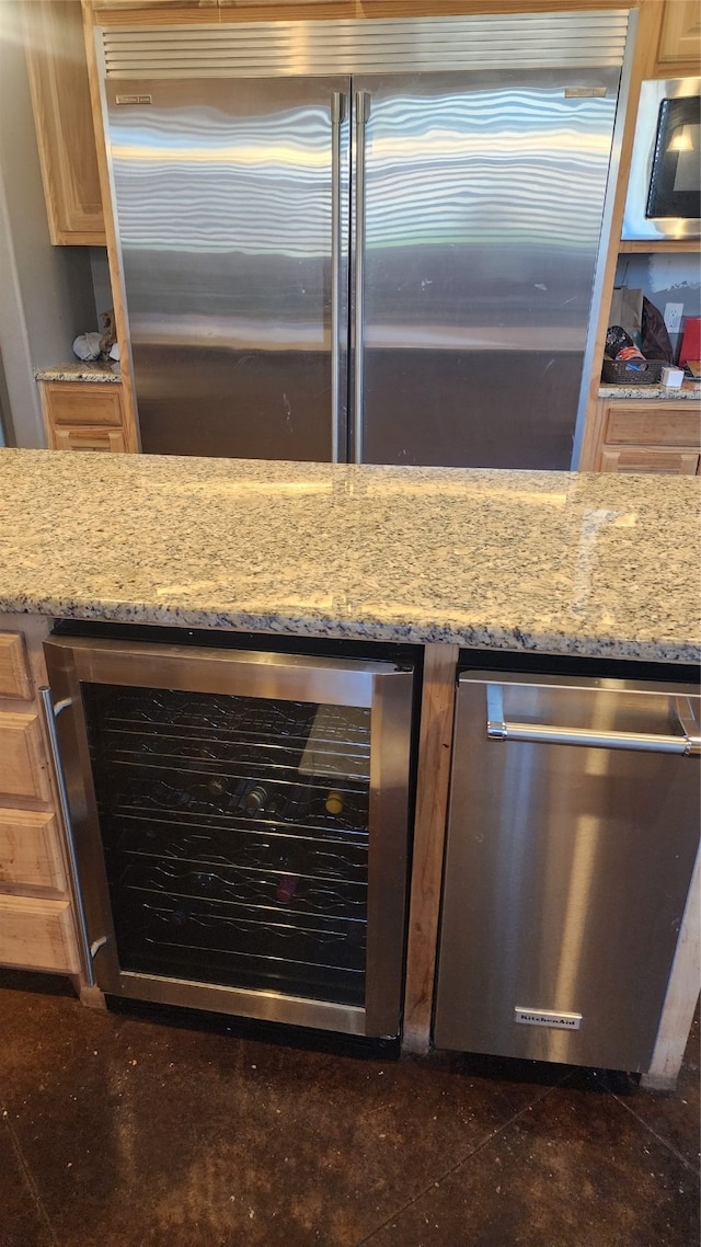 kitchen with wine cooler, light stone counters, and stainless steel appliances