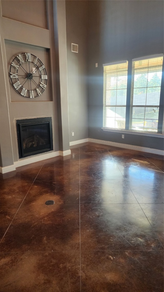 unfurnished living room with a towering ceiling