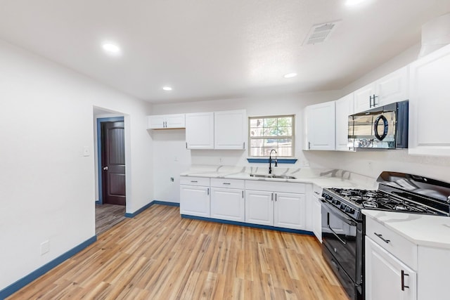 kitchen with sink, black appliances, and white cabinets