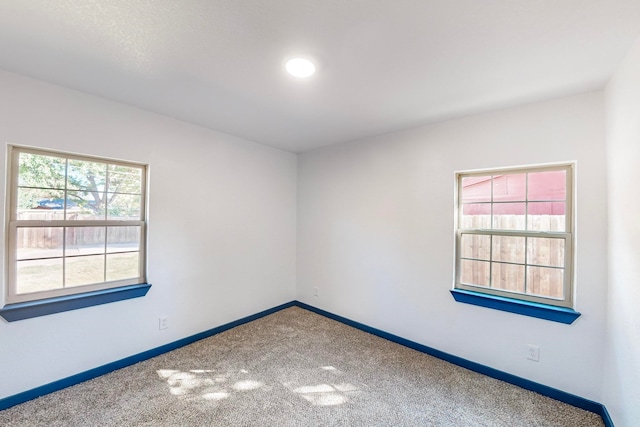 carpeted spare room featuring a healthy amount of sunlight