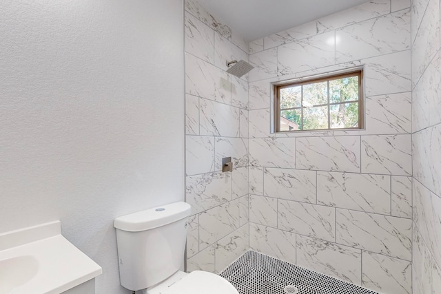 bathroom featuring vanity, toilet, and tiled shower