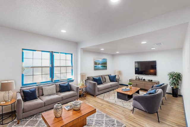 living room with light hardwood / wood-style flooring and a textured ceiling