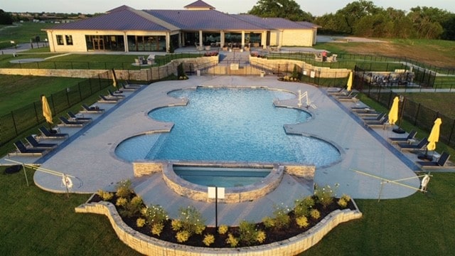 view of pool featuring a patio, a hot tub, and a lawn