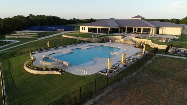 view of swimming pool featuring a hot tub, a yard, and a patio area