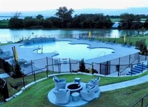 view of swimming pool with a yard and a water view