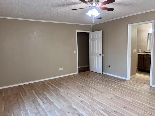 unfurnished bedroom featuring ensuite bathroom, crown molding, a textured ceiling, light hardwood / wood-style flooring, and ceiling fan