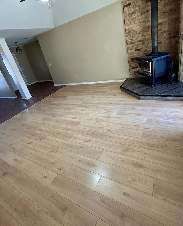 unfurnished living room with a wood stove and light hardwood / wood-style floors