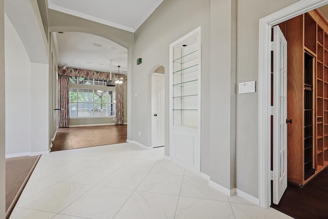 foyer with ceiling fan, ornamental molding, and light hardwood / wood-style flooring