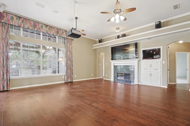 unfurnished living room with a tiled fireplace, ornamental molding, hardwood / wood-style floors, and ceiling fan