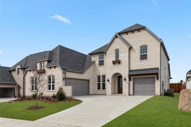 french country style house featuring roof with shingles, concrete driveway, and brick siding