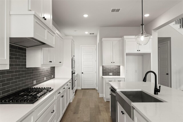 kitchen featuring stainless steel appliances, white cabinetry, and a sink