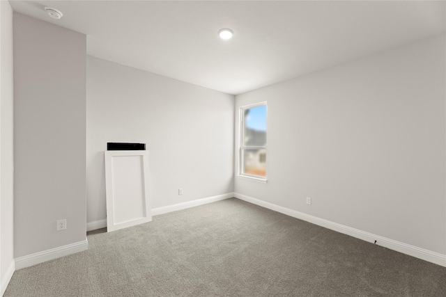unfurnished room featuring carpet and baseboards