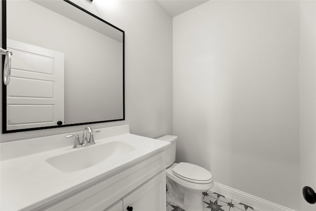 bathroom featuring vanity, baseboards, and toilet