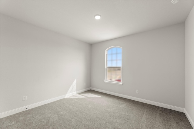 spare room featuring carpet floors and baseboards