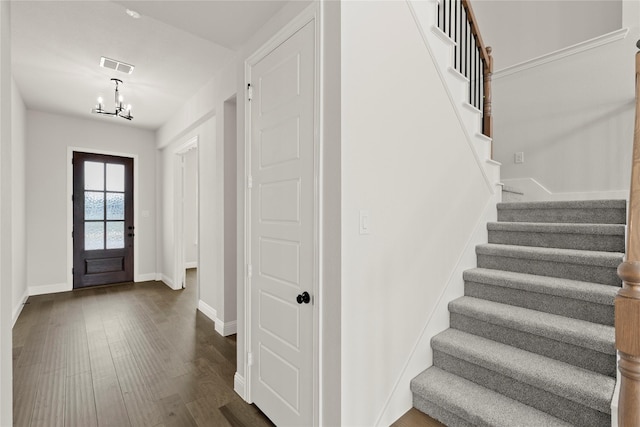 entrance foyer with baseboards, an inviting chandelier, stairway, visible vents, and dark wood finished floors