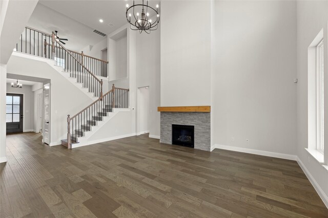 unfurnished living room with wood finished floors, baseboards, visible vents, and stairs