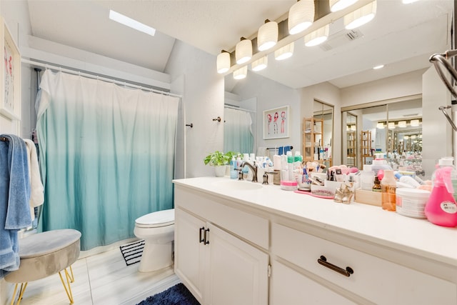 bathroom with toilet, walk in shower, and vanity