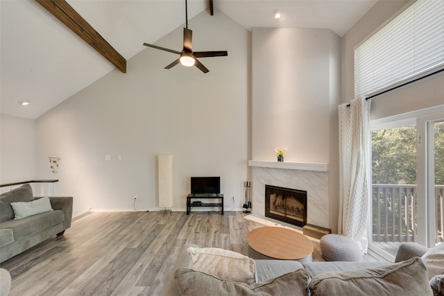 living room with light hardwood / wood-style floors, a premium fireplace, high vaulted ceiling, and beamed ceiling