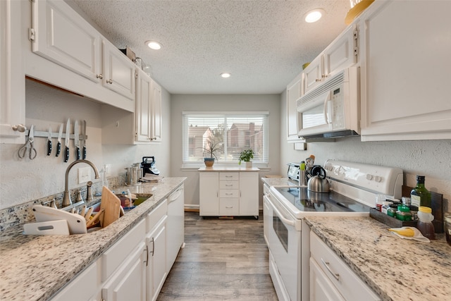 kitchen featuring white cabinets, a textured ceiling, light hardwood / wood-style floors, sink, and white appliances