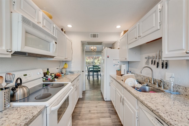 kitchen with sink, white cabinetry, white appliances, and light hardwood / wood-style floors