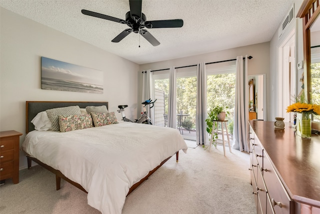 carpeted bedroom featuring access to outside, a textured ceiling, and ceiling fan