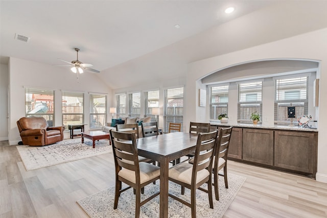 dining area with vaulted ceiling, ceiling fan, and light wood-type flooring