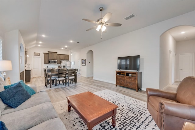 living room with ceiling fan, lofted ceiling, and light wood-type flooring