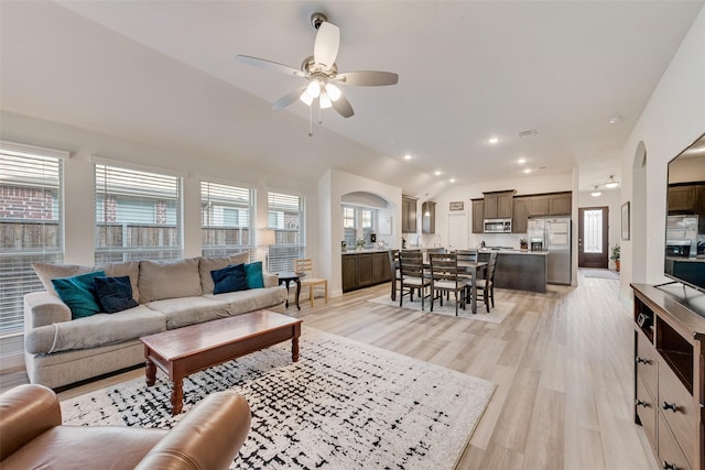 living room with ceiling fan, lofted ceiling, and light hardwood / wood-style floors