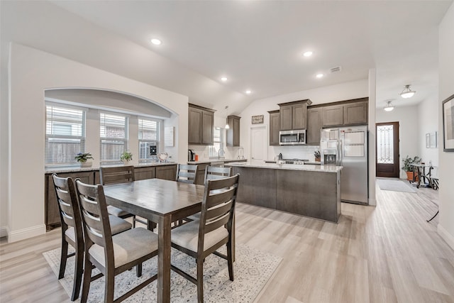 dining area with lofted ceiling and light hardwood / wood-style floors