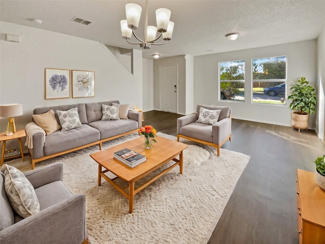 living room with a notable chandelier, a textured ceiling, and wood-type flooring